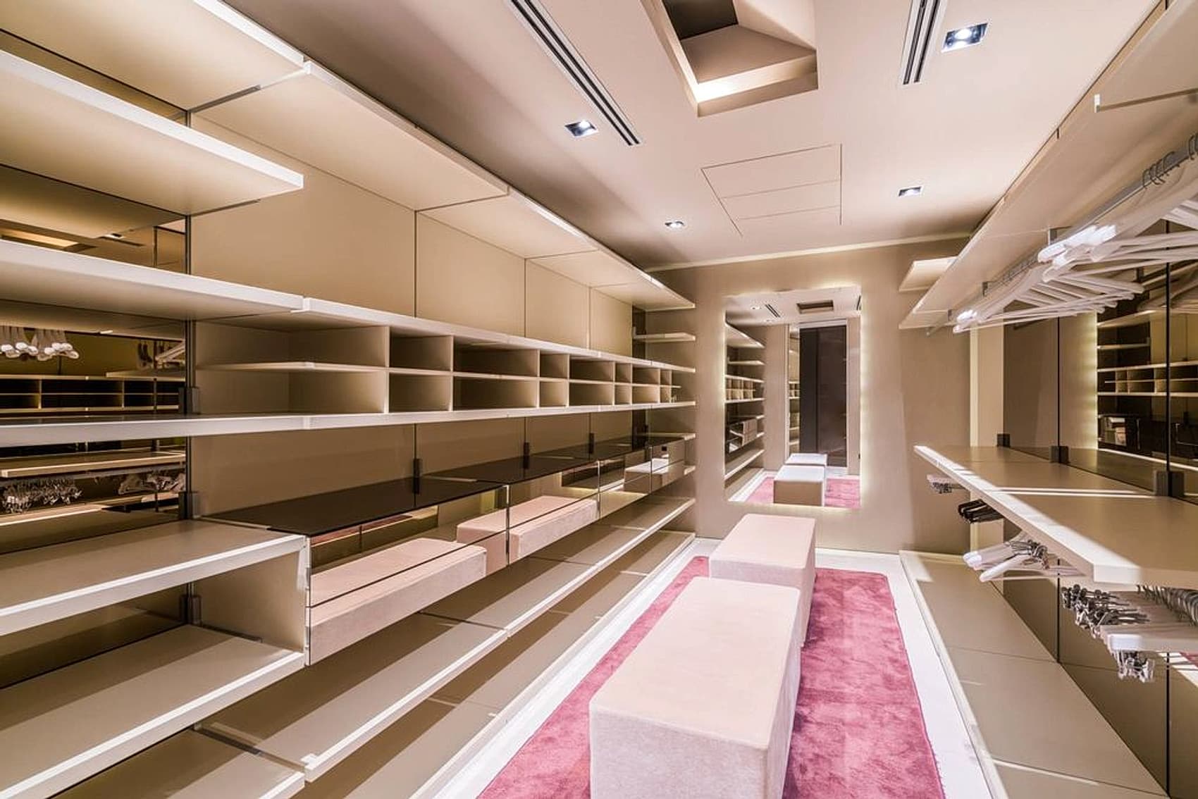 Luxury walk-in wardrobe with soft lighting and seating