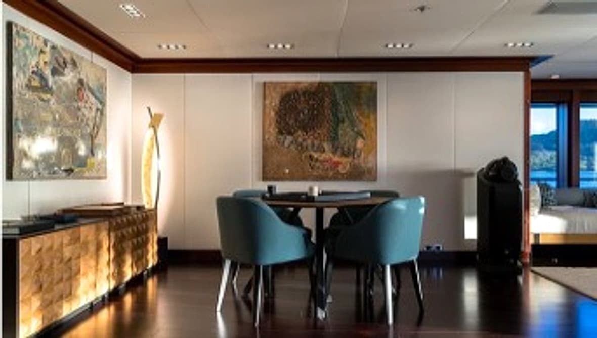 Interior yacht dining space with art and guest seating